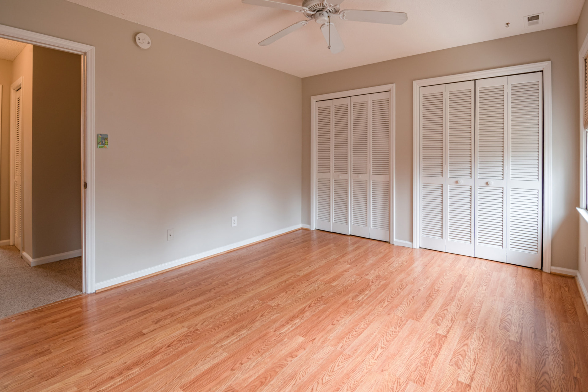 Empty bedroom with clean wood floors and closet doors, ready for a move-out cleaning walkthrough