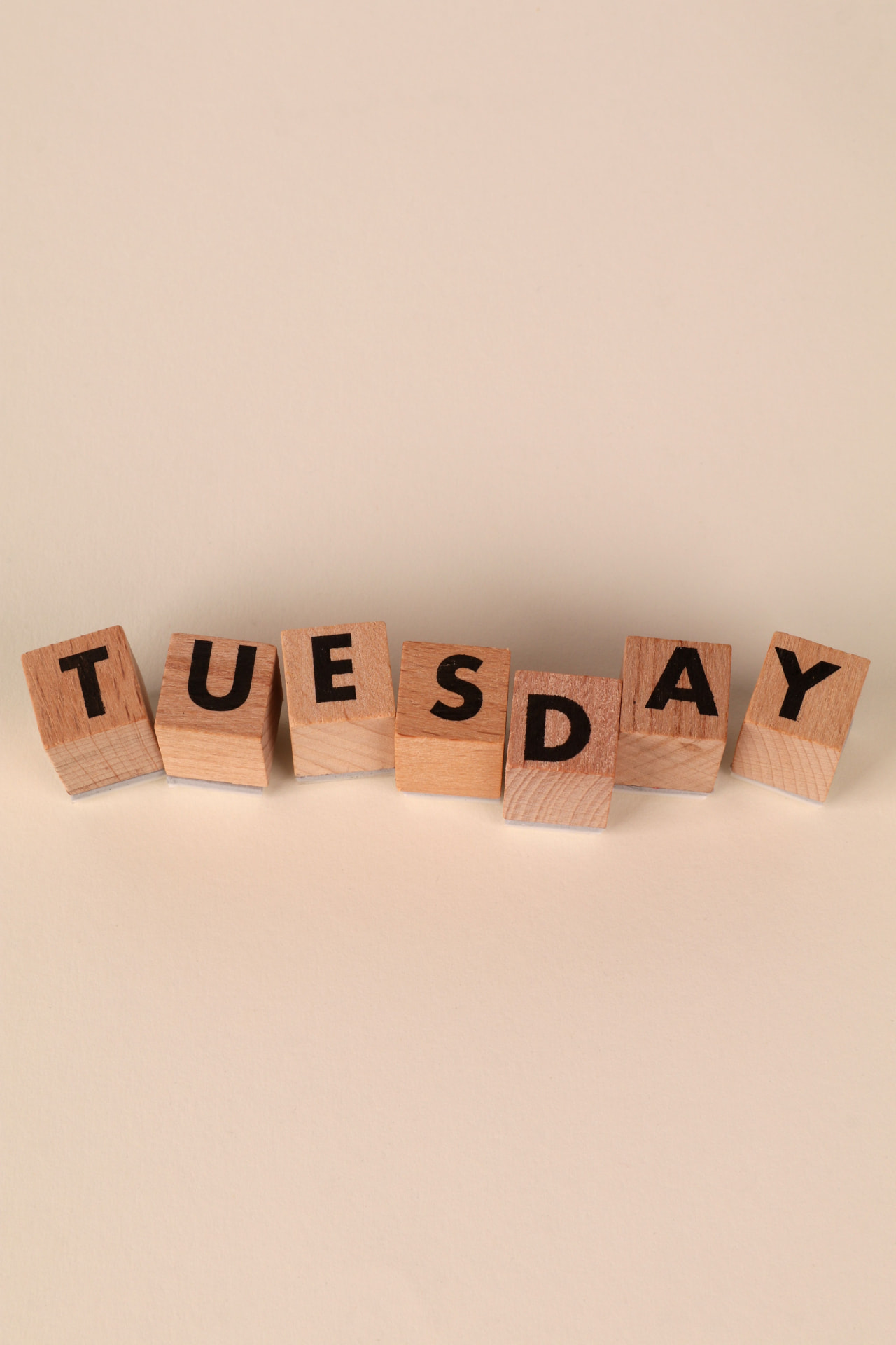 Wooden blocks spelling the word Tuesday, marking a recurring cleaning day