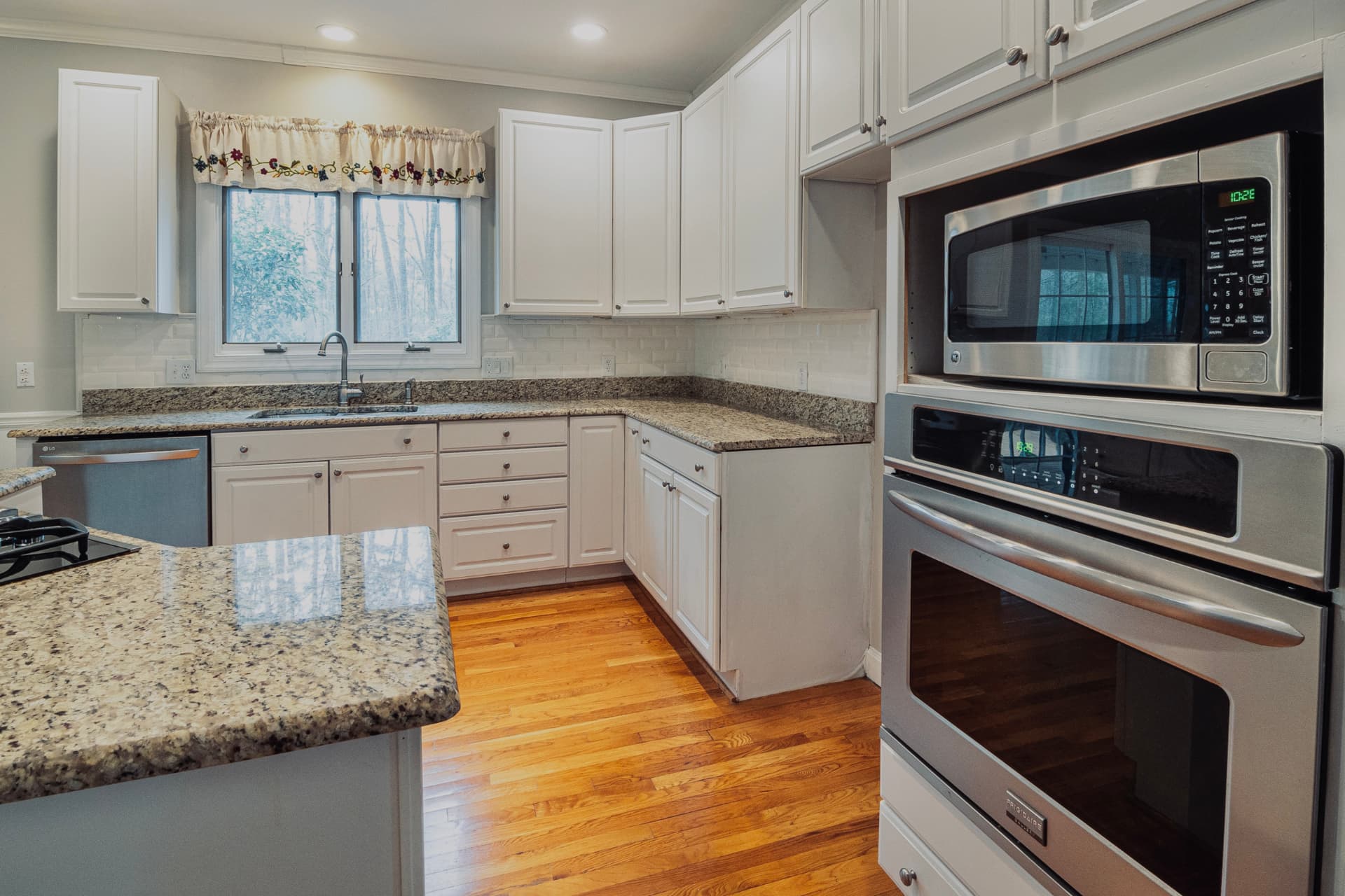 Spotless white kitchen with granite counters in a Westlake OH home after a deep clean